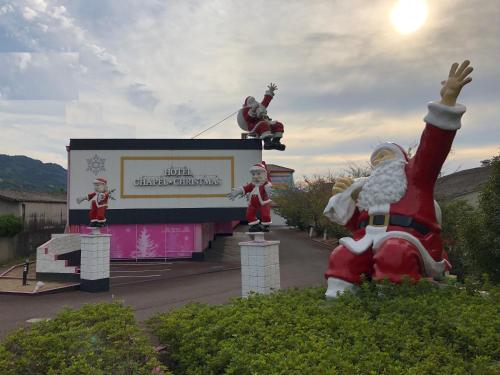 a santa claus statue in front of a sign at Koyasan ホテル チャペル クリスマス かつらぎ Adult Only in Katsuragi