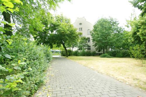 a brick path in front of a white house at Green Residence Boutique Lofts & Villa am Park in Offenbach