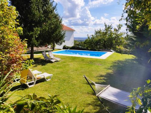 un patio con 2 sillas y una piscina en Casa da Gardunha, en Cortiçada