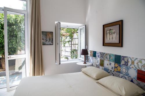 a bedroom with a white bed and a window at La Casetta di Sotto in Forio d'Ischia