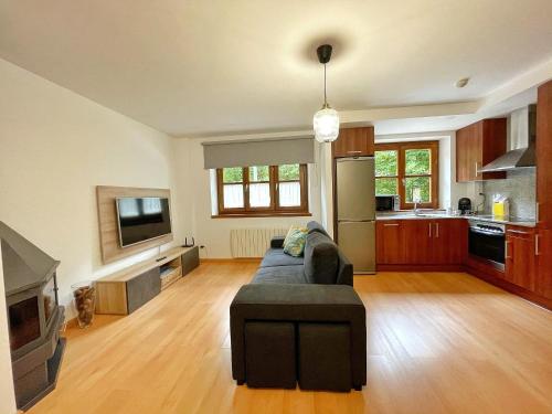 Apartamento Casa Chloe في بيناسكي: غرفة معيشة كبيرة مع أريكة ومطبخ