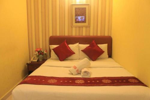 a bedroom with a large bed with red and white pillows at Sun Inns Kelana Jaya in Petaling Jaya