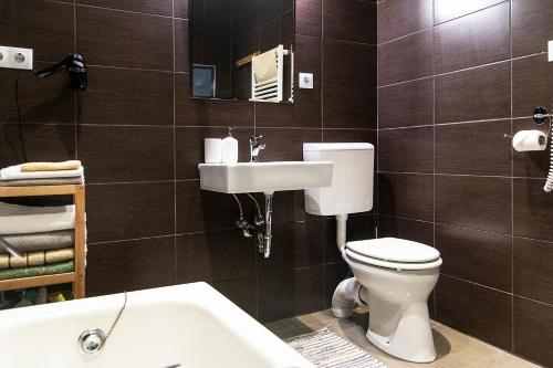 a bathroom with a toilet and a sink and a tub at Pipa Apartment in Budapest