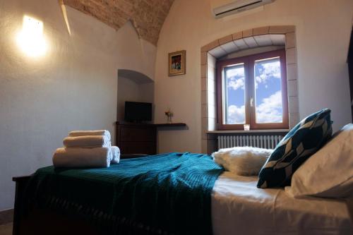 1 dormitorio con 1 cama grande y ventana en Tenuta Ulivi, en Putignano