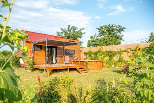 a tiny house with a deck in a yard at myinsolite - Tiny-house, jacuzzi, brasero, piscine in Aigues-Mortes