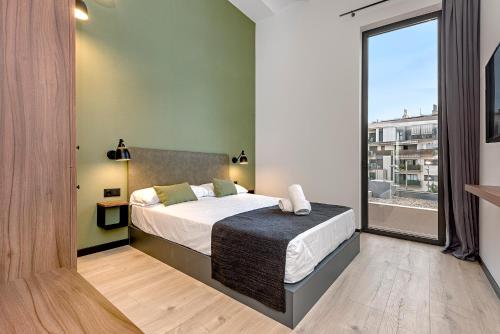 a bedroom with a bed and a large window at Hotel Orangine in Hospitalet de Llobregat