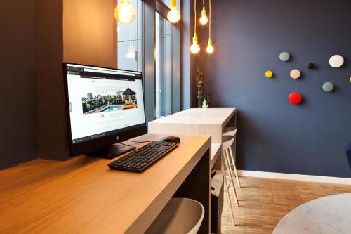 a computer monitor sitting on a desk with a keyboard at Holiday Inn Express - Recklinghausen in Recklinghausen
