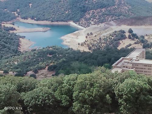an aerial view of a lake and a building at Le Gite du Barrage in Zaouia Ben Smine