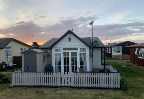 a white house with a fence in a yard at Chalet 81 South Shore Bridlington 2x Bedroom Detached Chalet Sleeps 4 in Bessingby