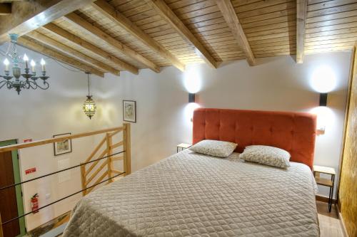 a bedroom with a bed with a orange headboard at Quinta dos Caseiros do Paço de Giela in Arcos de Valdevez