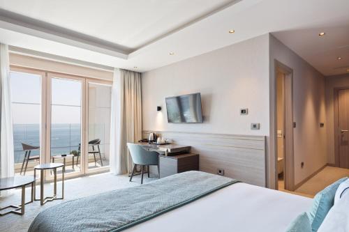 a hotel room with a bed and a desk at Hotel AMI Budva Petrovac in Petrovac na Moru