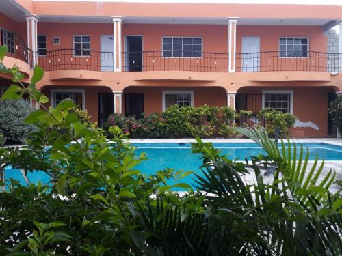 an apartment building with a swimming pool in front of it at Apartahotel Next Nivel - Queen Room with Fan in Punta Cana