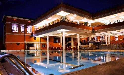 a building with a swimming pool at night at Olde Bangalore Resort and Wellness Center in Devanahalli-Bangalore