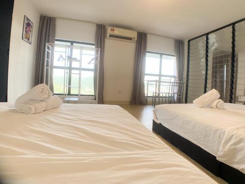 a bedroom with two beds with white sheets and windows at Colonial9 Suite (Sunrise & Mountain View)@Empire City in Petaling Jaya