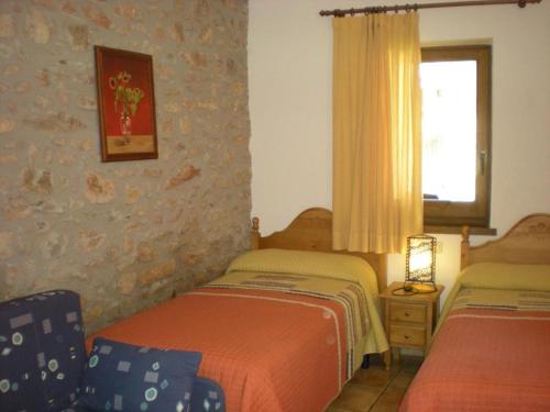 a bedroom with two beds and a window at Cal Pedrals II in Urus