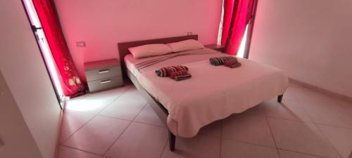 - une chambre avec un lit aux murs roses et des rideaux rouges dans l'établissement Sal Service beachside angulo, à Santa Maria