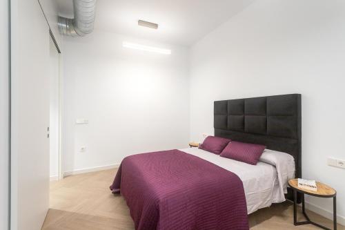 een slaapkamer met een groot bed en een paarse deken bij Luxury Rental Spain in Alicante