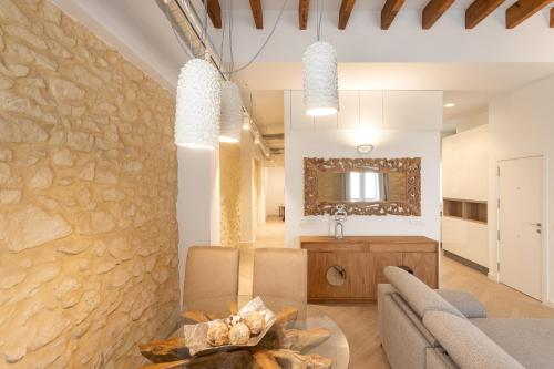 een eetkamer en een woonkamer met een stenen muur bij Luxury Rental Spain in Alicante