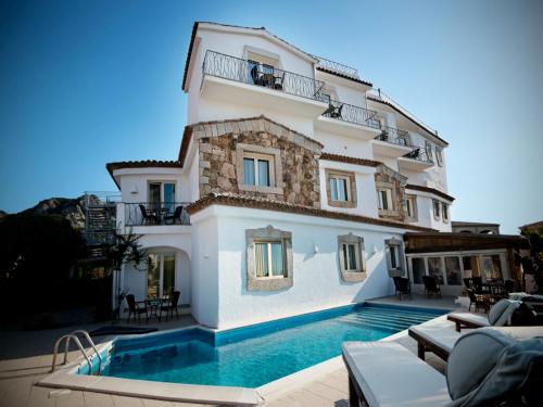 una villa con piscina di fronte a un edificio di Dolce Vita Boutique Hotel a Porto Cervo
