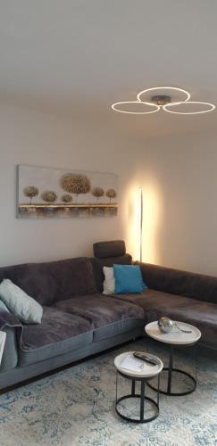 ein Wohnzimmer mit einem braunen Sofa und 2 Tischen in der Unterkunft Bed and Breakfast Mittelkärnten in Althofen