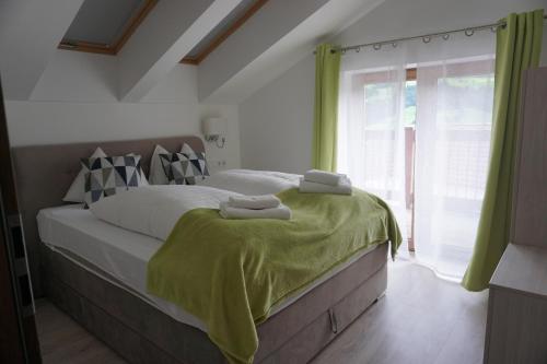 Un dormitorio con una cama con una manta verde. en Schneekristall, en Aich