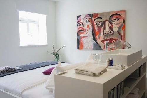 a bedroom with a bed with a painting on the wall at Ferienwohnungen Mittermurnthal in Neunburg vorm Wald