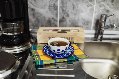 a cup of coffee sitting on a plate next to a sink at City Center Studio in Belgrade