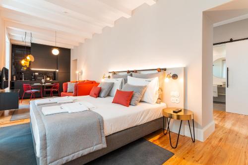 um quarto com uma grande cama branca com almofadas vermelhas em FLH Viola Market Studios no Funchal