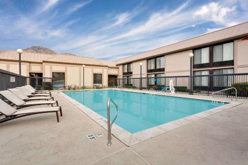 a pool at a hotel with lounge chairs around it at Ramada by Wyndham Provo in Provo