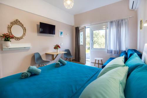 a bedroom with a blue bed and a table at Doukas Apartments Luxury Living in Skala Marion