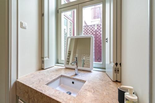 een badkamer met een wastafel en een spiegel bij Baixa Charming Apartment in Lissabon