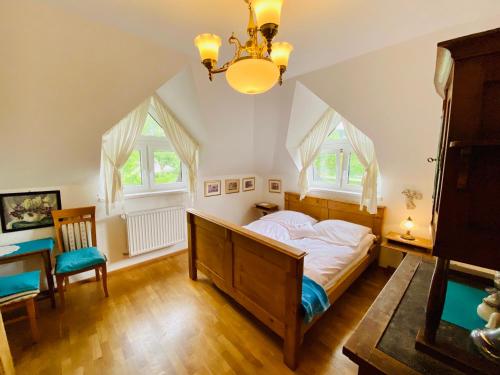 a bedroom with a bed and a table and two windows at Agroturystyka „Na Połomiu” in Istebna