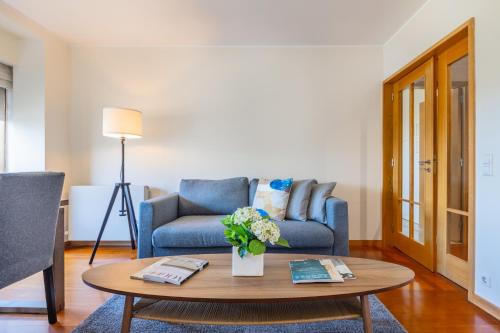 ein Wohnzimmer mit einem blauen Sofa und einem Couchtisch in der Unterkunft Foz Premium Retreat in Porto