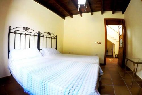 1 dormitorio con 1 cama grande con sábanas blancas en Casa Tía Ines en Vilaflor