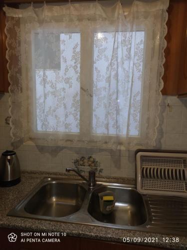 a sink in a kitchen with a window at Lovely Eleana Apartment in Corfu in Corfu Town