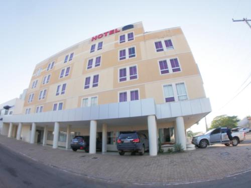 a hotel with two cars parked in front of it at Jalapão Hotel in Palmas