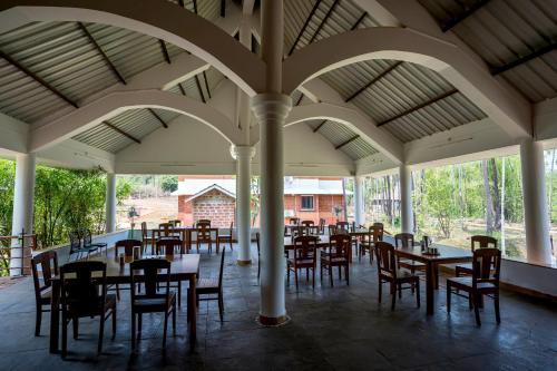 een eetkamer met tafels en stoelen in een paviljoen bij Sarth Ayurveda Retreat and Wellness Centre in Sawantwadi