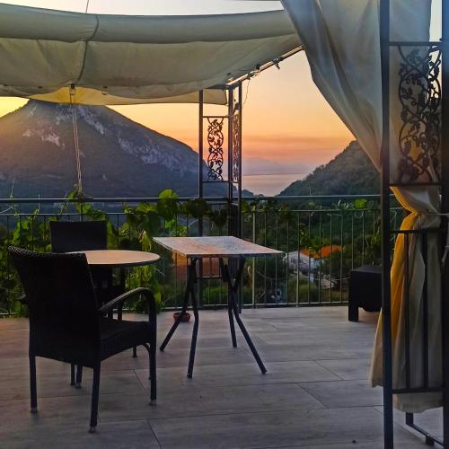 a patio with two tables and a view of a mountain at La Roccia Incantata Amalfi Coast in Vietri sul Mare