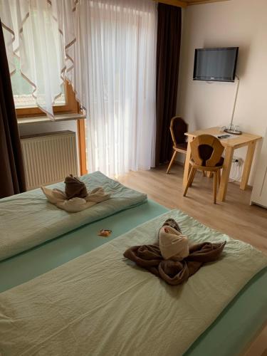 a hotel room with two beds with towels on them at Pension Kleiner in Eging