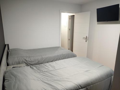 two beds in a small room with a television at Apartamentos Hi Apartaments Santander 3000 in Maliaño