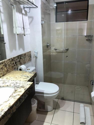 y baño con ducha, aseo y lavamanos. en FLAT NATAL PLAZA, en Natal