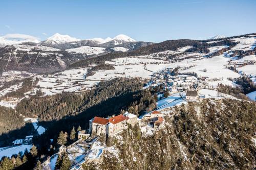 a castle on top of a mountain in the snow at Pension Volgger in Rodengo