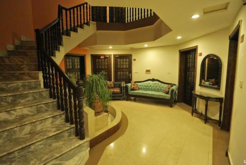ein Wohnzimmer mit einer Treppe und einer Couch in der Unterkunft Prestige Boutique Hotel & Resorts in Islamabad