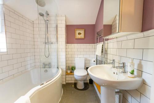 a bathroom with a tub and a sink and a toilet at Middlethorpe Manor - No1 Relax and Unwind in York