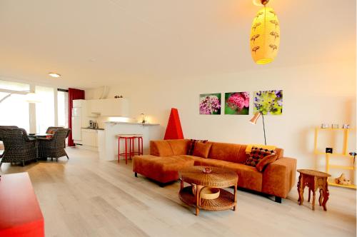a living room with a couch and a table at Kustverhuur, Appartement aan zee, Port Scaldis 05042 in Breskens