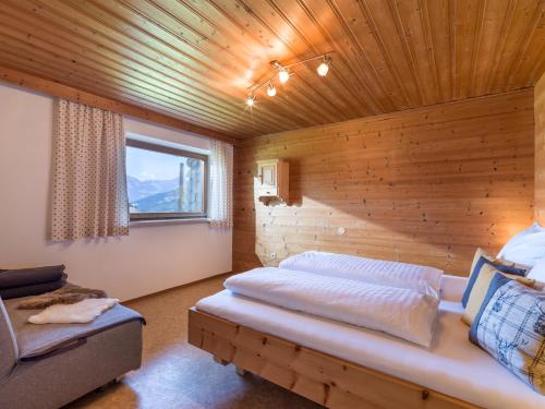 um quarto com uma cama e uma parede de madeira em Appartement Salvenblick em Hopfgarten im Brixental
