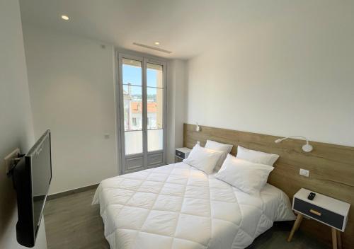 une chambre avec un grand lit blanc et une fenêtre dans l'établissement Viva Riviera Deluxe Top Floor 2 Bedrooms 2 Bathrooms, à Cannes