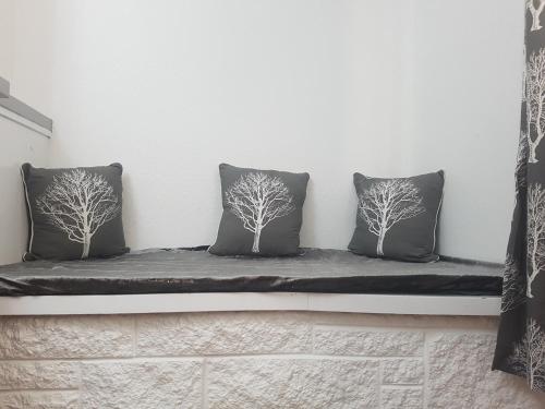 two pillows sitting on a bench against a wall at Cosy Room in Galashiels in Galashiels