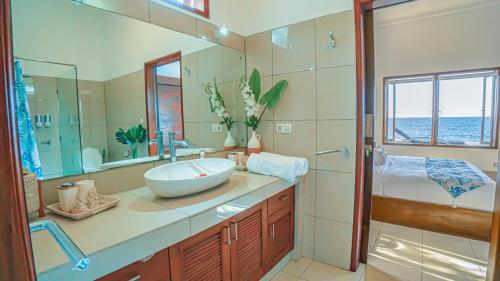 a bathroom with a sink and a large mirror at Air Sanih Beach Villa in Kubutambahan