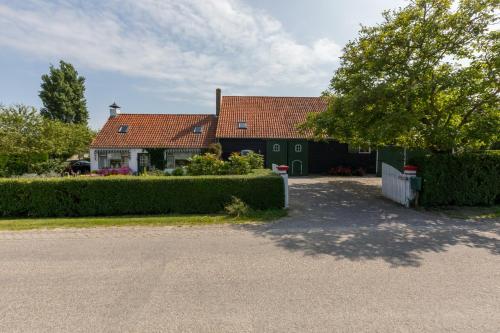 a house with two green doors and a driveway at De Notenboom in Meliskerke